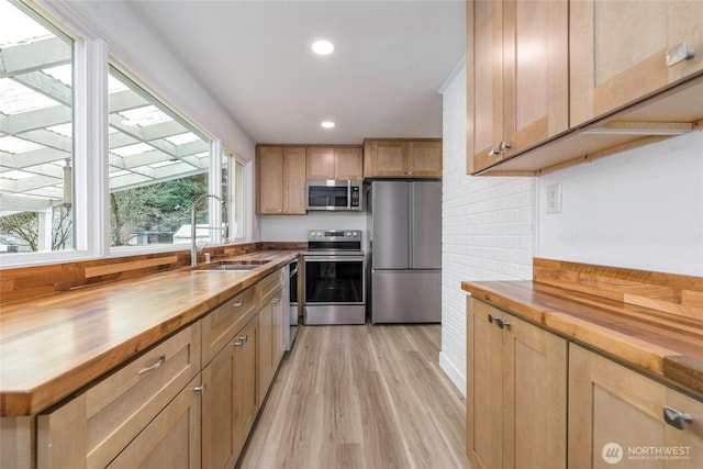 kitchen featuring light wood-style flooring, recessed lighting, stainless steel appliances, and butcher block countertops