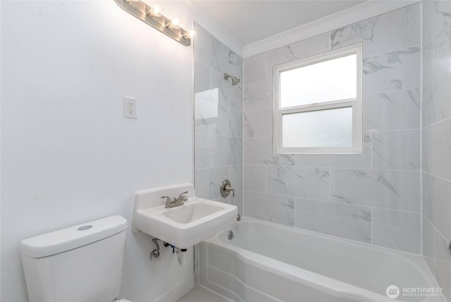 bathroom with crown molding, toilet, washtub / shower combination, and a sink