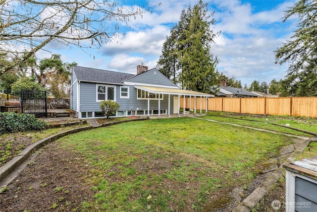 rear view of house with a yard, fence private yard, roof with shingles, and a chimney