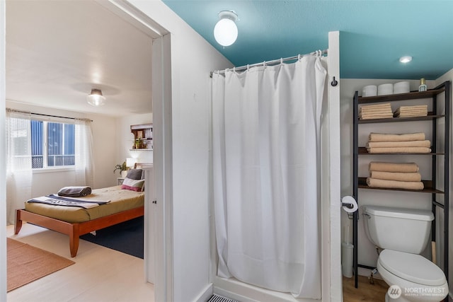 full bath with a shower with shower curtain, toilet, and wood finished floors