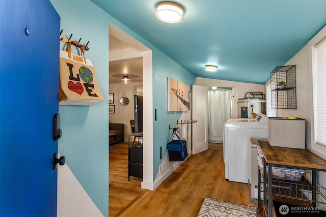 hallway with washer / clothes dryer, wood finished floors, water heater, and baseboards