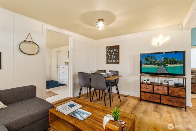 living room featuring a decorative wall and wood finished floors