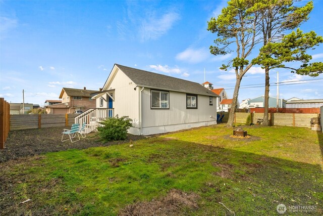 back of property with a lawn and a fenced backyard