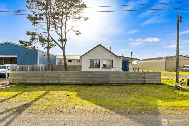 view of front facade featuring an outbuilding, a fenced front yard, and a pole building