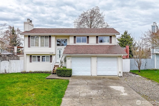 bi-level home featuring concrete driveway, a front yard, and fence