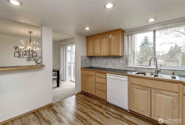 kitchen with light brown cabinets, light wood-style flooring, white dishwasher, a sink, and tasteful backsplash