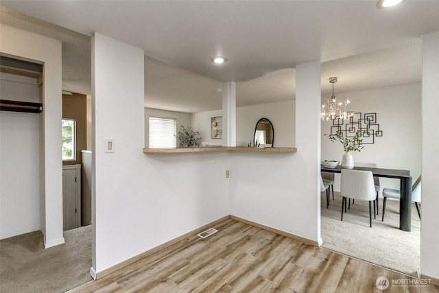 kitchen featuring recessed lighting, wood finished floors, visible vents, and baseboards