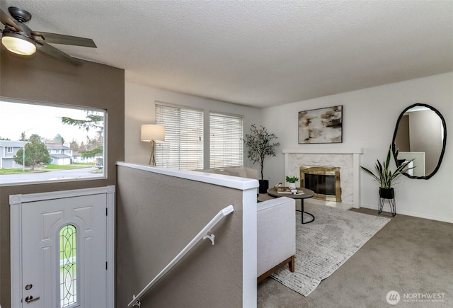 living room featuring a textured ceiling, carpet, and a premium fireplace