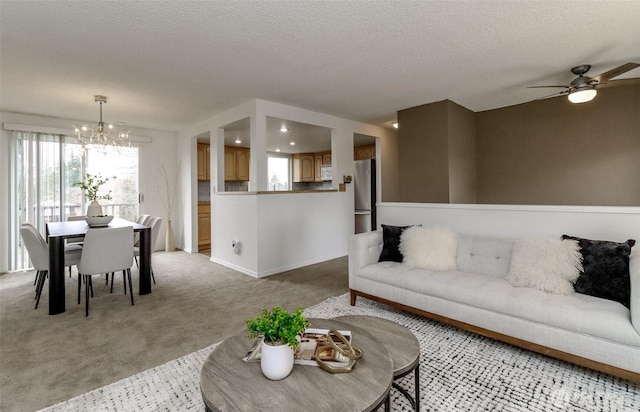 living area with baseboards, light carpet, a textured ceiling, and an inviting chandelier