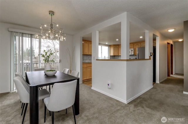 dining space with baseboards, plenty of natural light, and light colored carpet