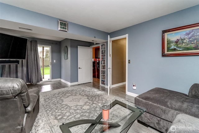 living area with visible vents, baseboards, and wood finished floors