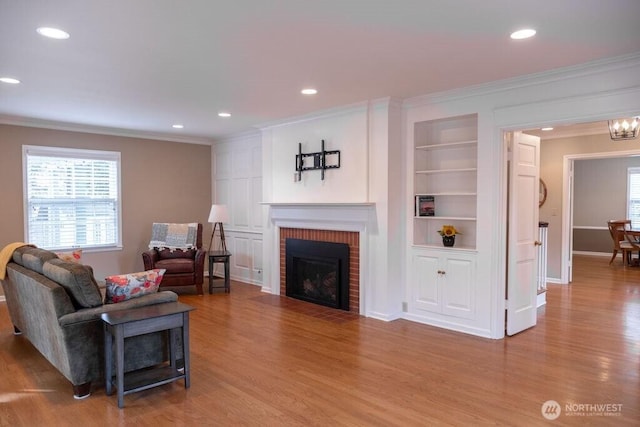 1120 Home Ave, Walla Walla, WA 99362 - living room with crown molding, plenty of natural light, wood finished floors, built in shelves, and a fireplace