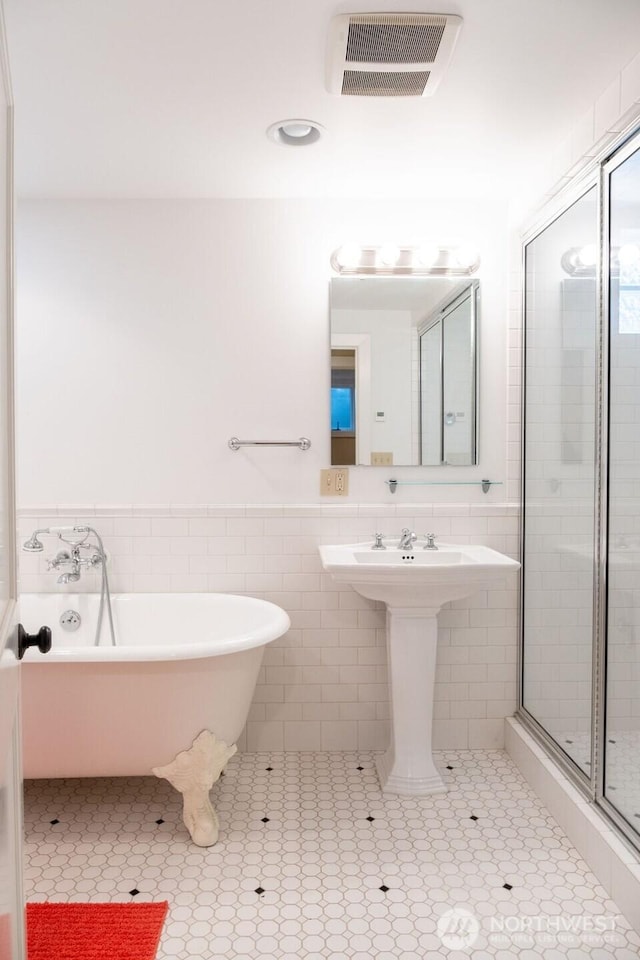 1120 Home Ave, Walla Walla, WA 99362 - bathroom with tile walls, a soaking tub, a wainscoted wall, a shower stall, and tile patterned floors