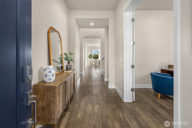 hall with dark wood-type flooring and baseboards