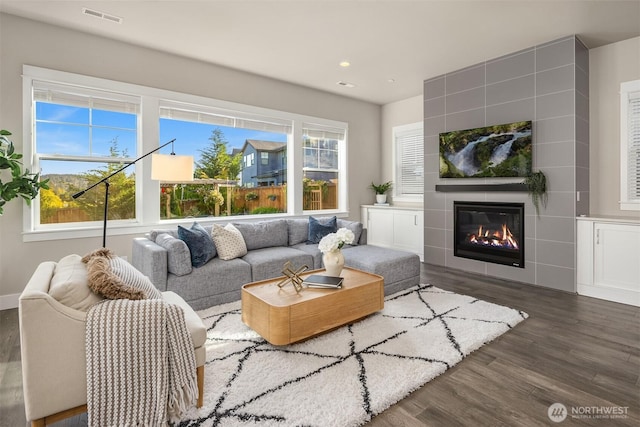 living area featuring recessed lighting, visible vents, wood finished floors, and a fireplace