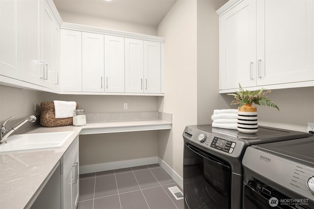 clothes washing area with baseboards, light tile patterned flooring, cabinet space, a sink, and washer and dryer