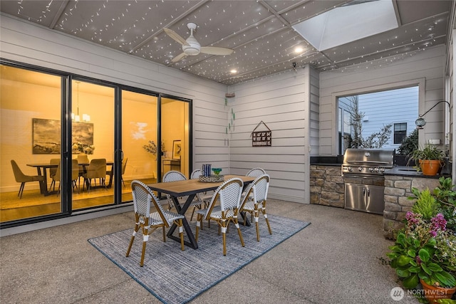 dining space with a ceiling fan and wood walls