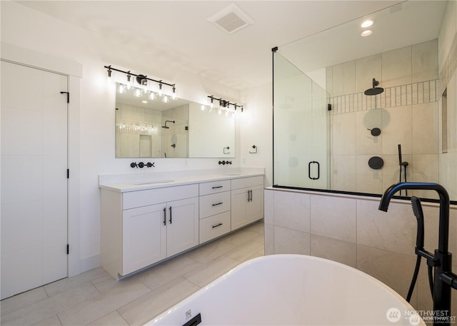 full bath featuring a freestanding bath, a shower stall, visible vents, and a sink