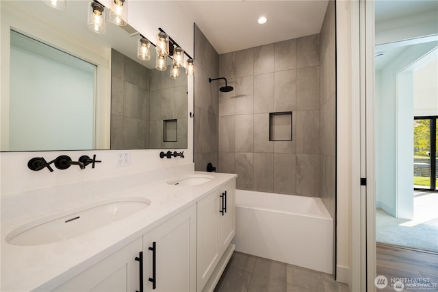 full bath with a sink, double vanity, recessed lighting, and washtub / shower combination