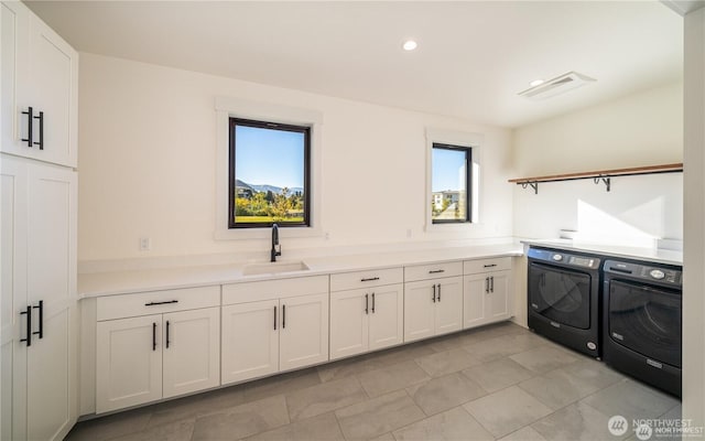 washroom featuring a sink, cabinet space, independent washer and dryer, and recessed lighting