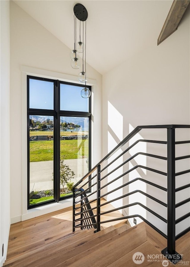 staircase with vaulted ceiling and wood finished floors