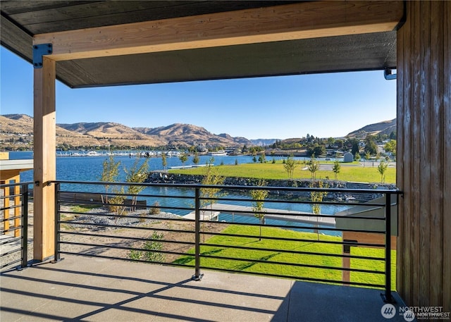 view of patio featuring a water and mountain view and a balcony