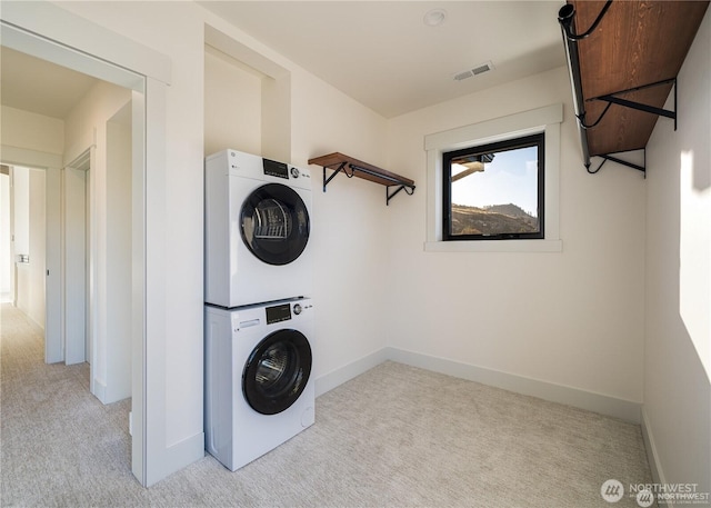 clothes washing area featuring visible vents, baseboards, light colored carpet, laundry area, and stacked washing maching and dryer