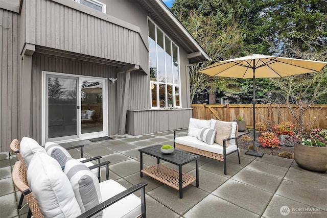 view of patio featuring outdoor lounge area and fence