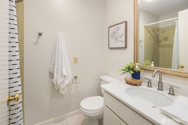 bathroom with tile patterned flooring, baseboards, toilet, tiled shower, and vanity