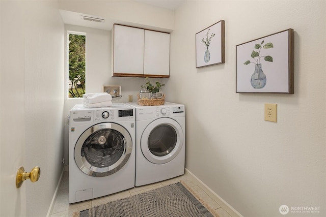 laundry area with light tile patterned floors, visible vents, baseboards, cabinet space, and washing machine and dryer