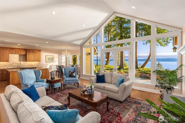 living room with recessed lighting, light wood-style flooring, high vaulted ceiling, and an inviting chandelier