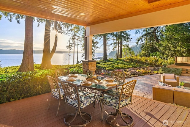 wooden terrace featuring an outdoor living space, outdoor dining area, and a water view