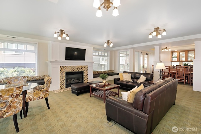 living area featuring a fireplace, light colored carpet, visible vents, and a healthy amount of sunlight