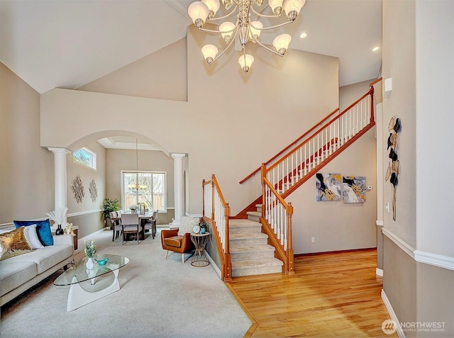 living area featuring arched walkways, high vaulted ceiling, an inviting chandelier, and stairs