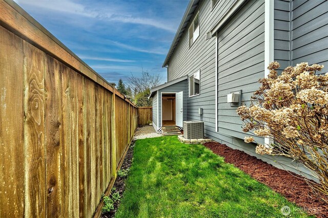 view of yard with entry steps, cooling unit, and fence