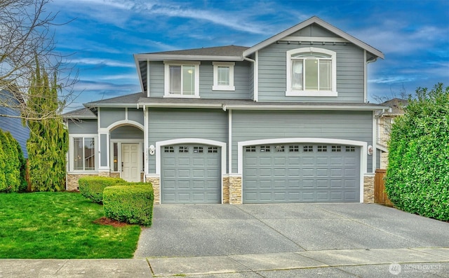 view of front facade featuring stone siding, a front lawn, concrete driveway, and an attached garage