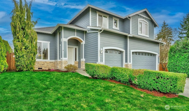 view of front of property featuring stone siding, a front yard, and an attached garage