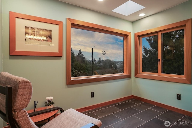 sitting room featuring a skylight, dark tile patterned floors, recessed lighting, and baseboards