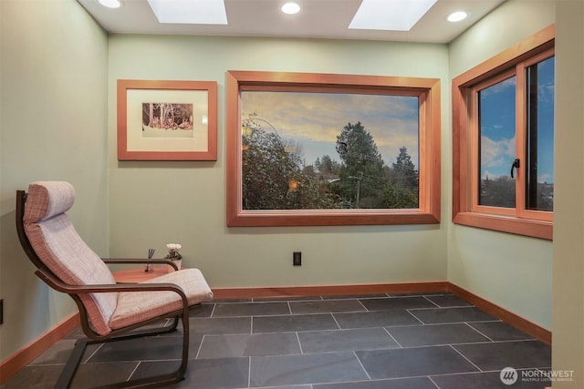 living area with a skylight, recessed lighting, and baseboards