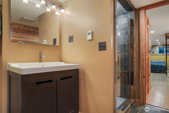 full bath featuring a shower with door and vanity