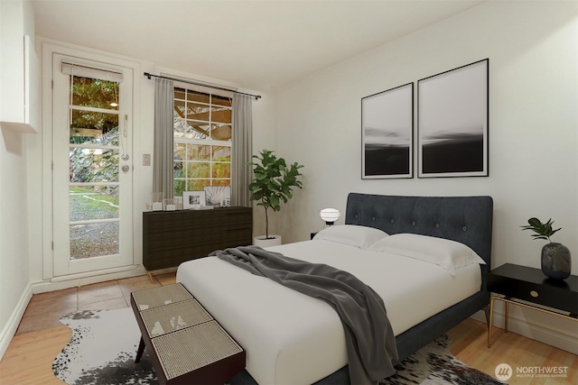 bedroom featuring access to exterior, wood finished floors, and baseboards