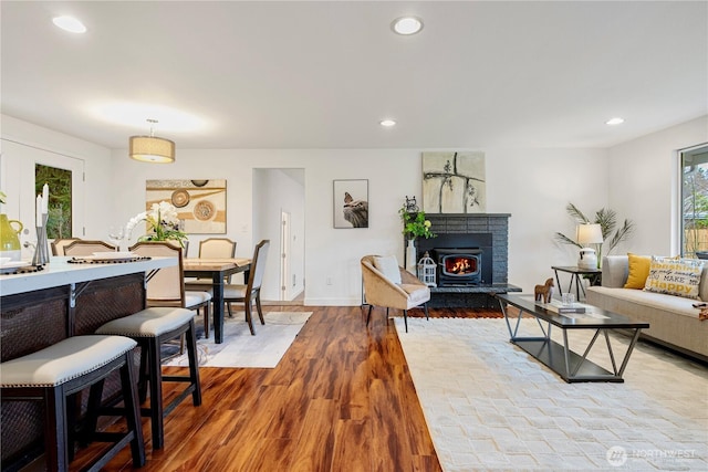 living room with recessed lighting, a fireplace, baseboards, and wood finished floors