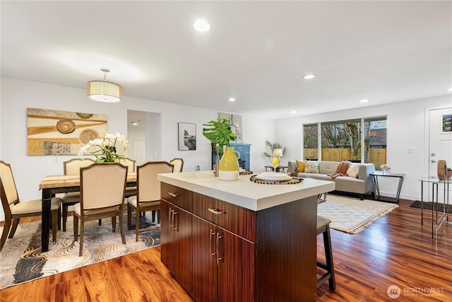 kitchen featuring a center island, dark wood finished floors, pendant lighting, a breakfast bar area, and recessed lighting