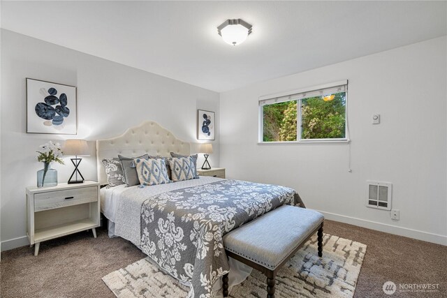 bedroom with heating unit, baseboards, and carpet floors