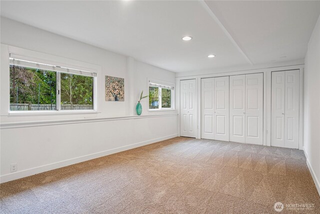 unfurnished bedroom featuring carpet flooring, recessed lighting, two closets, and baseboards