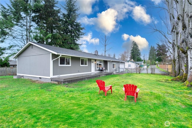 rear view of house with crawl space, a yard, a chimney, and fence