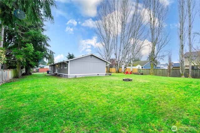 view of yard featuring a fire pit and a fenced backyard