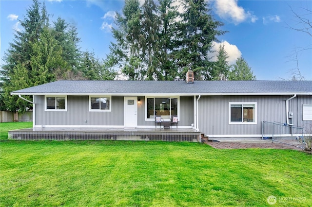 single story home with a shingled roof, a front lawn, and a chimney