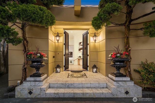 property entrance with stucco siding and a patio