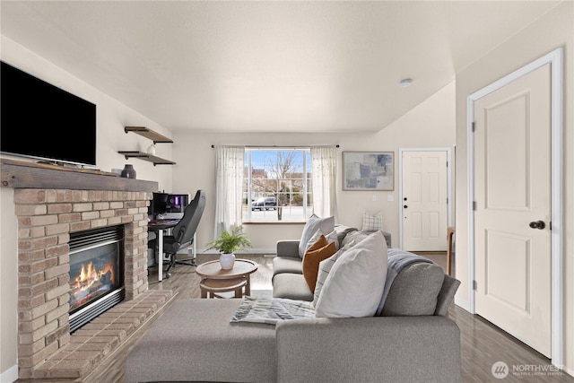 living area with baseboards, wood finished floors, and a fireplace